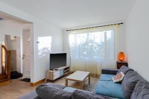 a living room with a couch and a tv at Maison de vacances in Sarlat-la-Canéda