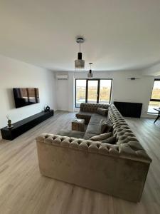 ein Wohnzimmer mit einer großen Couch in der Mitte in der Unterkunft Apartament Bucuresti Nord in Bukarest