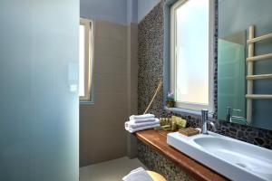 a bathroom with a sink and a tub and a window at Althea Boutique Hotel - Adults Only in Amoopi