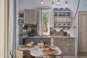 a kitchen with a wooden table with chairs and a counter at Althea Boutique Hotel - Adults Only in Amoopi