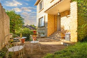 a patio with chairs and a table in front of a house at Maison de vacances in Sarlat-la-Canéda