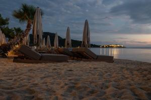 a group of chairs and umbrellas on a beach at Oniro Boutique Hotel in Toroni