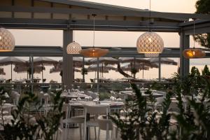 a restaurant with white tables and chairs and umbrellas at Oniro Boutique Hotel in Toroni