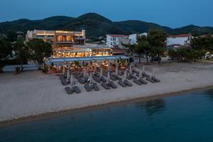a building on the beach with chairs and the water at Oniro Boutique Hotel in Toroni