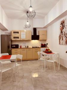 a kitchen with white chairs and a table and a table and a kitchen at Noclegi AVATAR Radom in Radom