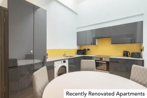a kitchen with a white table and chairs at Holyrood Aparthotel in Edinburgh