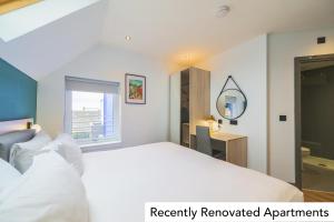 a bedroom with a bed and a desk and a mirror at Holyrood Aparthotel in Edinburgh
