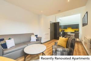 a living room with a couch and two chairs at Holyrood Aparthotel in Edinburgh