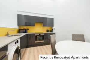 a kitchen with a sink and a dishwasher at Holyrood Aparthotel in Edinburgh