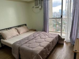 a bedroom with a bed and a large window at Zinnia North Tower 3202 in Manila +21 photos
