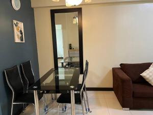 a dining room with a glass table and chairs at Zinnia North Tower 3202 in Manila
