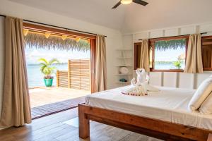 a bedroom with a bed with a view of the ocean at Sol Bungalows Bocas del Toro in Bocas del Toro