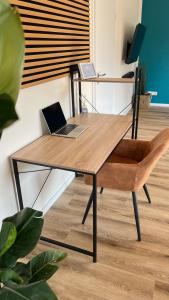 a wooden desk with a laptop and a chair at Großes Apartment für 6 - Gasgrill Citynah Parken in Lippstadt