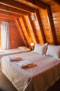 a bedroom with two beds in a wooden house at Cabañas Nevis, excelente ubicación in El Calafate