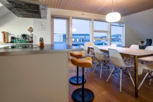イルリサットにあるIlulissat Stay - 4-bedroom villa with sea view and hot tubのテーブルと椅子のあるキッチンとダイニングルーム