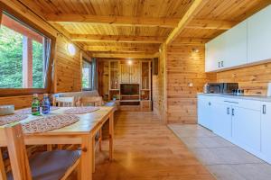 a kitchen and dining room with a table in a cabin at Pensjonat Kwiatkowski domek nr 1 in Nowęcin +23 photos