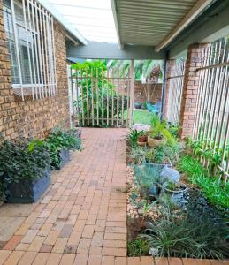 un giardino con un edificio in mattoni e un sentiero in mattoni di The Adler Studio apartment a Boksburg