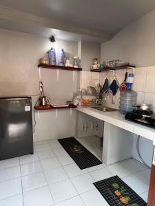 a small kitchen with a sink and a refrigerator at Julio Amed Guest House in Karangasem +31 photos