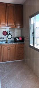 una cucina con armadi in legno e un lavandino in camera di Apartement ensoleillé au centre de Tanger a Tangeri Altre 8 foto