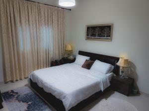 una camera da letto con un letto con lenzuola bianche e una finestra di Modern Space in Prime Location a Dubai