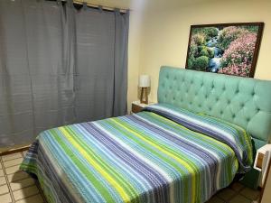 Un dormitorio con una cama con una manta a rayas. en SANBERJERE, en San Bernardo