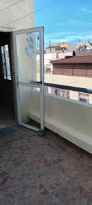 una porta scorrevole in vetro su un balcone con finestra di Apartement ensoleillé au centre de Tanger a Tangeri