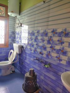 a bathroom with blue and white flowers on the wall at New Summer Capital in Shimla