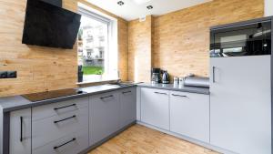 eine Küche mit weißen Schränken und einem Fenster in der Unterkunft Apartament Karo II in Świeradów-Zdrój + 4 Fotos