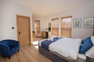 a bedroom with a bed and a blue chair at Amber Hotel in Hull