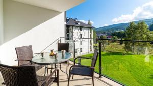 ein Balkon mit Tisch und Stühlen und Aussicht in der Unterkunft Apartament Karo II in Świeradów-Zdrój