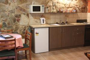 eine Küche mit einem weißen Kühlschrank und einer Mikrowelle in der Unterkunft Langmeil Cottages in Tanunda