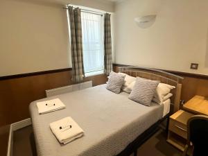 a bedroom with a bed with two towels on it at The Marker Hotel in London