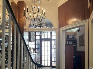 a hallway with a chandelier and a stairway at The Marker Hotel in London
