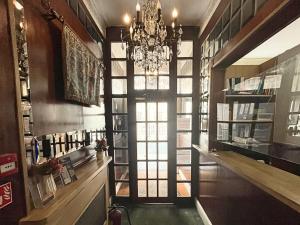 a room with a chandelier and a hallway with a door at The Marker Hotel in London