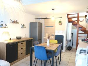 马赛Maison de village à 35 m du bord de mer的厨房以及带桌子和蓝色椅子的用餐室。