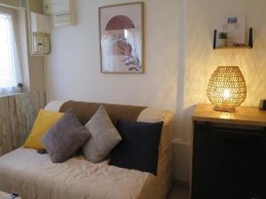 马赛Maison de village à 35 m du bord de mer的客厅配有沙发、枕头和台灯