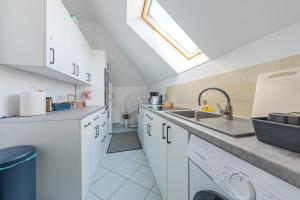 una cucina con mobili bianchi e un lavandino di Pensjonat Kwiatkowski apartament nr 3 a Nowęcin