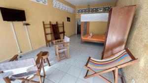 a room with a room with chairs and a television at Studio Ylang - Vue mer & détente à Nosy Be in Nosy Be