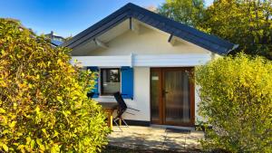 een klein wit huis met een houten deur bij Ferienhaus Seepferdchen in Göhren +6 foto's