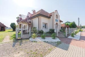 a house with a white fence in front of it at Pensjonat Kwiatkowski apartament nr 4 in Nowęcin