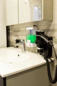 a hair dryer on a counter next to a sink at Ojakalda Puhkekeskus in Piigaste