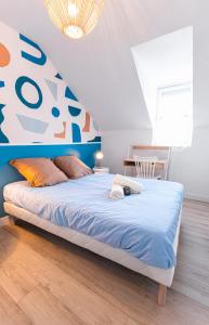 a bedroom with a bed with a blue and orange headboard at La Mancelle - 6 Personnes - Plein cœur du Mans in Le Mans