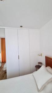 Boulevard Drobnera IV - Apartament nad Odrą - Rynek في فروتسواف: غرفة نوم بيضاء مع سرير ودواليب بيضاء +11 صورة