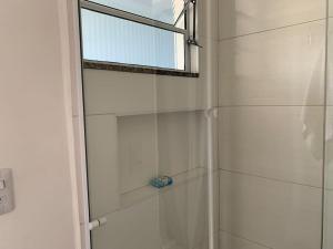 a shower with a glass door next to a window at Studio 21 Fácil acesso Aeroporto Internacional Guarulhos e Arena Corinthians in Sao Paulo +53 photos