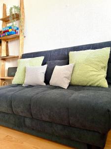 a blue couch with four pillows on it at Ferienwohnung Wolkenfrei mit Pool und Sauna in Scheidegg