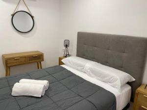 a bedroom with a large bed with a mirror on the wall at Edifico Mañez Segundo- Nuevo, 10 minutos Gibraltar in La Línea de la Concepción