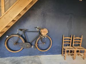 a bike hanging on a wall next to a chair at Bulle de campagne à Saint Benoit la Forêt in Saint-Benoît-la-Forêt