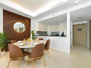 a dining room with a table and chairs and a mirror at Stunning 2BR with Burj View & Infinity Pool in Dubai