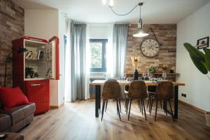 a dining room with a table and chairs and a clock at The Brick 194, 7 posti letto in Udine