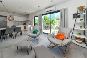 a kitchen and living room with chairs and a table at NEW Luxury 5BR Villa - Casa Graziano by Bocobay in Oranjestad